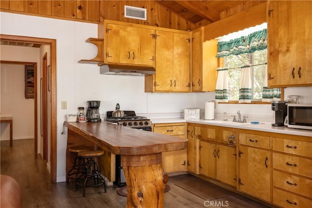 kitchen with wood ceiling, dark hardwood / wood-style flooring, vaulted ceiling with beams, sink, and stove