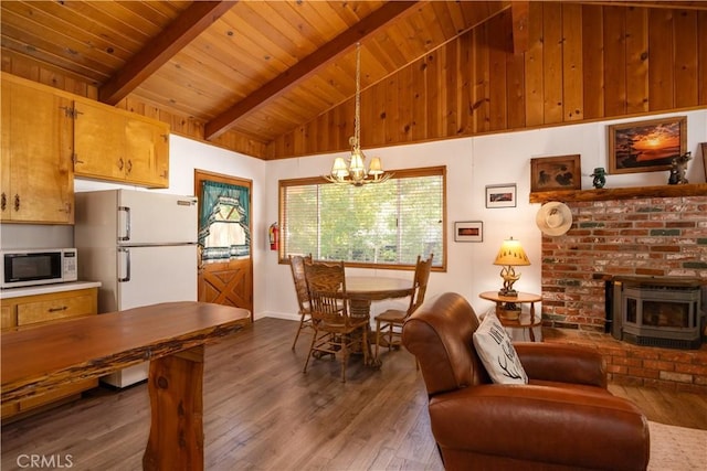 dining area featuring an inviting chandelier, wood ceiling, a wood stove, dark hardwood / wood-style flooring, and beamed ceiling