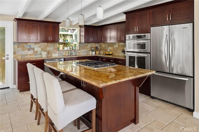 kitchen with decorative light fixtures, backsplash, a center island, sink, and stainless steel appliances