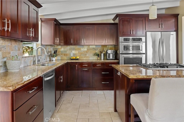 kitchen featuring tasteful backsplash, sink, hanging light fixtures, light stone countertops, and appliances with stainless steel finishes