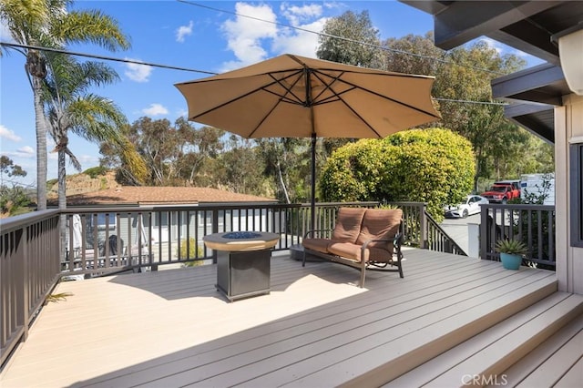 wooden terrace featuring an outdoor fire pit