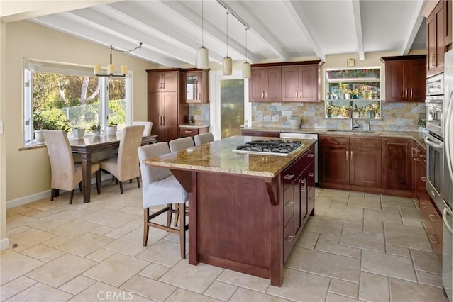 kitchen featuring tasteful backsplash, pendant lighting, a kitchen island, a breakfast bar, and sink