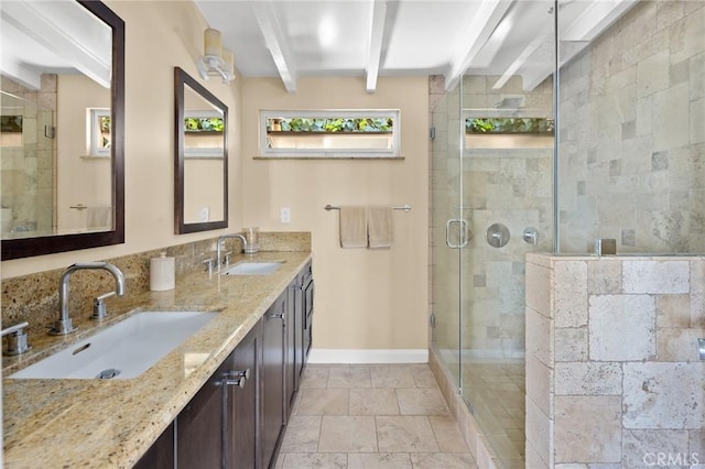 bathroom with vanity, a shower with door, and beamed ceiling