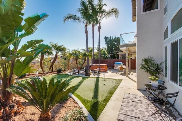 view of yard with a patio area, a hot tub, and a balcony