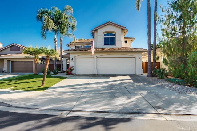 mediterranean / spanish home featuring a garage and a front lawn