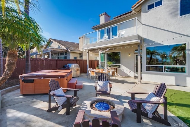 view of patio featuring a fire pit, grilling area, a hot tub, and a balcony