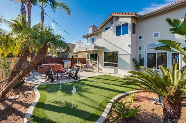 back of house featuring a balcony, a hot tub, and a patio area