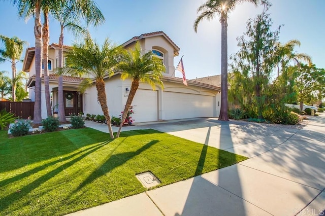 mediterranean / spanish house featuring a garage and a front yard