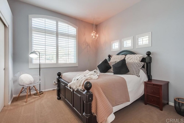 bedroom with a closet, light carpet, baseboards, and multiple windows