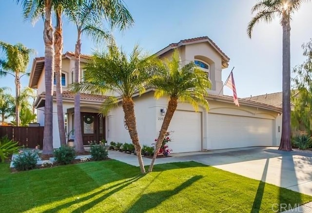 mediterranean / spanish-style home with concrete driveway, a tile roof, an attached garage, a front lawn, and stucco siding