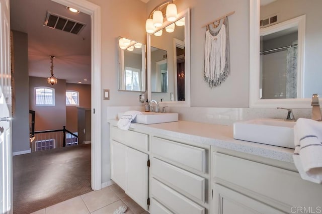 bathroom with double vanity, visible vents, a sink, and tile patterned floors