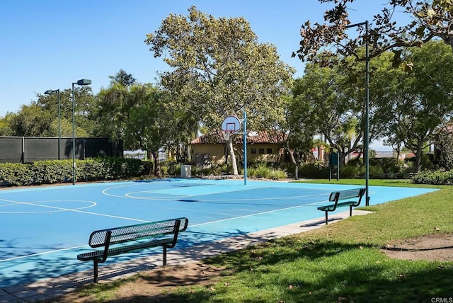 view of sport court with community basketball court, a lawn, and fence