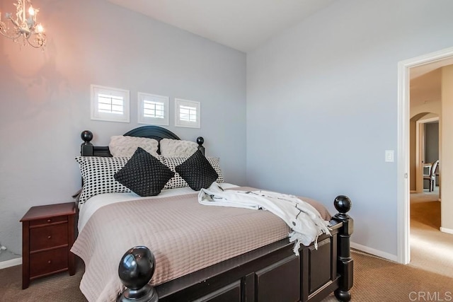 carpeted bedroom featuring arched walkways, baseboards, and a notable chandelier