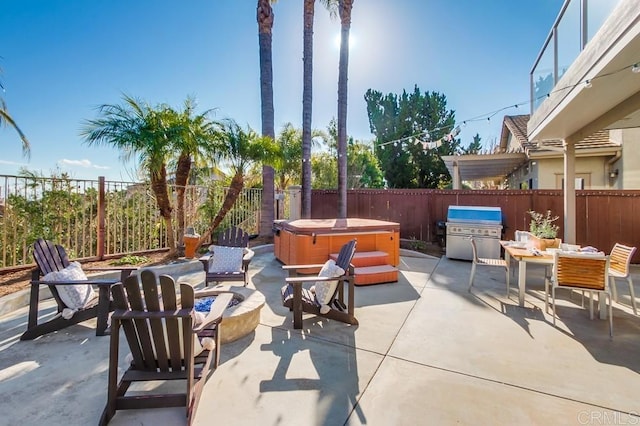 view of patio / terrace with a hot tub, a fenced backyard, and area for grilling