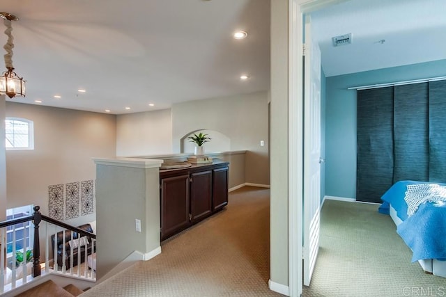 hallway with recessed lighting, light colored carpet, visible vents, an upstairs landing, and baseboards