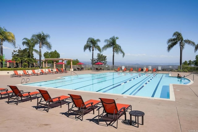 community pool with fence, a pergola, and a patio