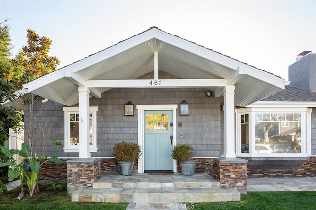 view of exterior entry with covered porch