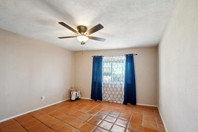 spare room featuring ceiling fan and light tile patterned floors