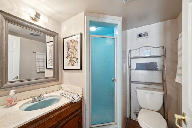 bathroom with an enclosed shower, vanity, and toilet