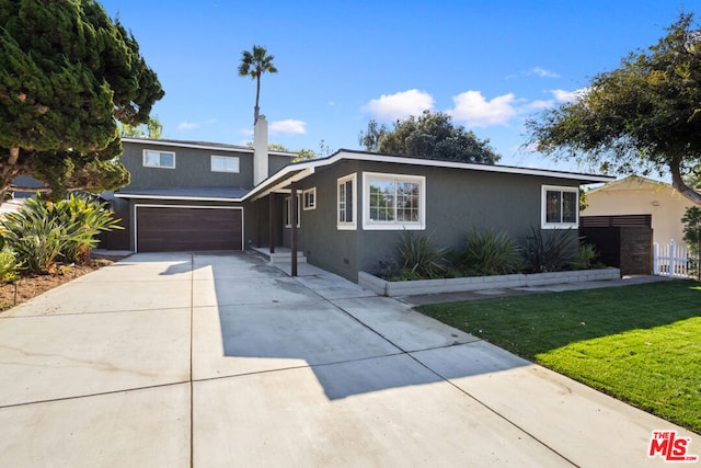 view of front of house featuring a garage and a front lawn