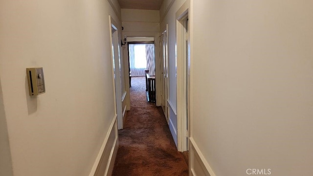 hallway featuring dark carpet