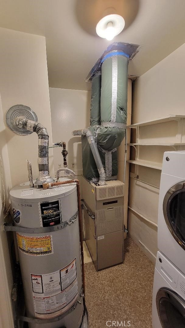 utility room featuring stacked washer and clothes dryer and gas water heater