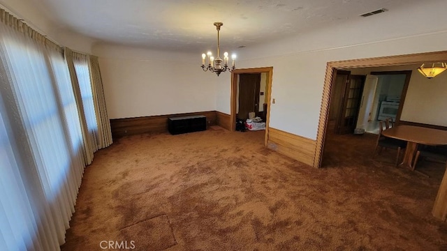 unfurnished dining area with dark colored carpet and a notable chandelier