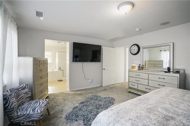 bedroom featuring light colored carpet and ensuite bathroom