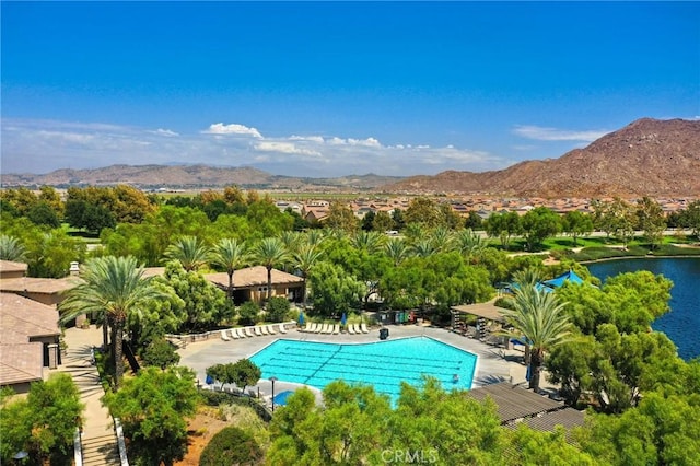 view of pool with a water and mountain view and a patio