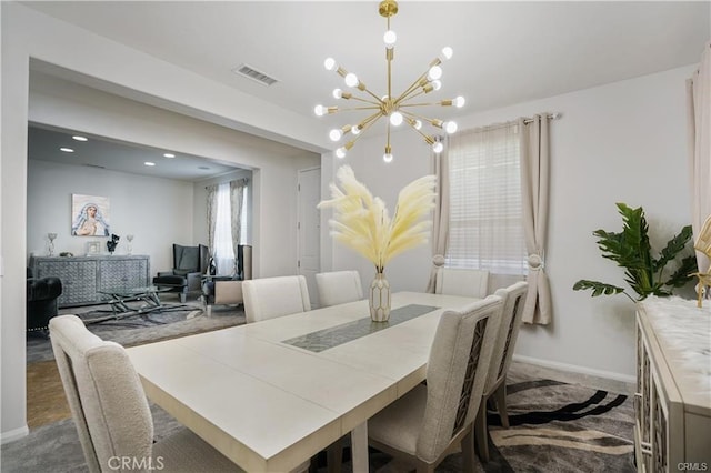 dining space featuring carpet and a chandelier