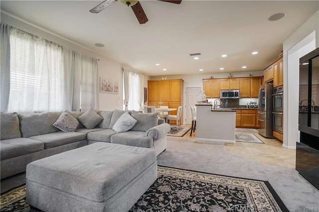 living room with ceiling fan and sink