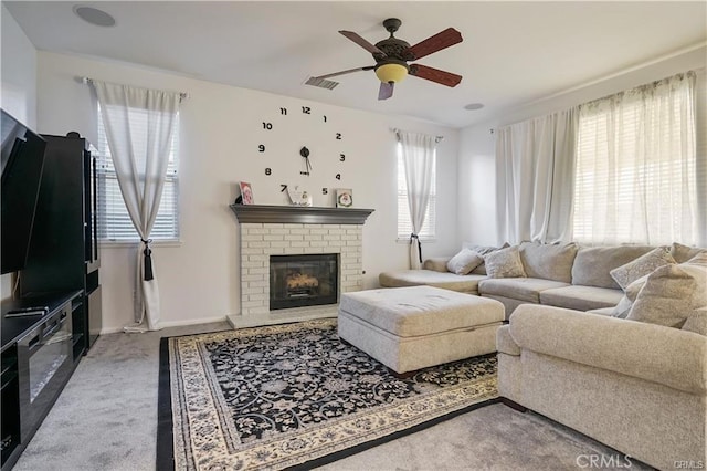 carpeted living room featuring ceiling fan and a fireplace