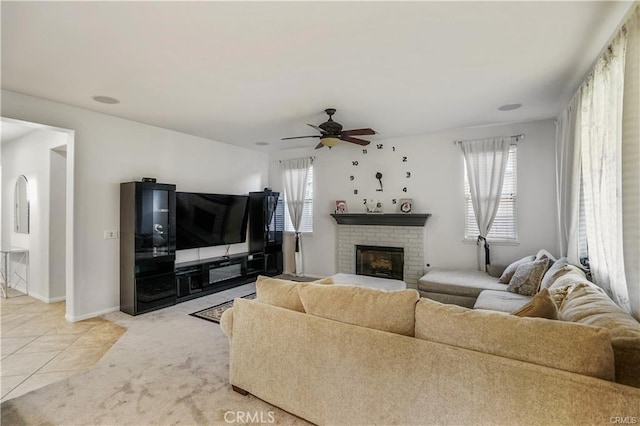 living room featuring ceiling fan, light tile patterned floors, and a fireplace