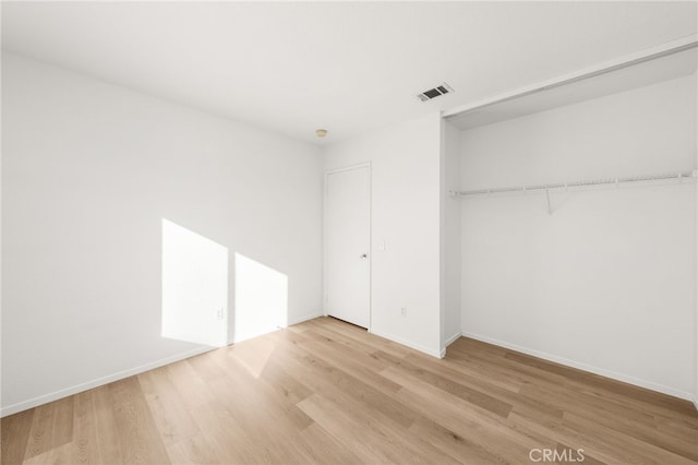 unfurnished bedroom with a closet and light hardwood / wood-style flooring