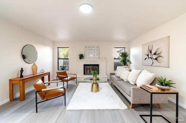 living room featuring a brick fireplace and light wood-type flooring