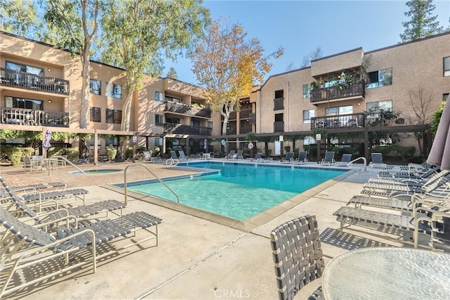 view of swimming pool with a hot tub and a patio