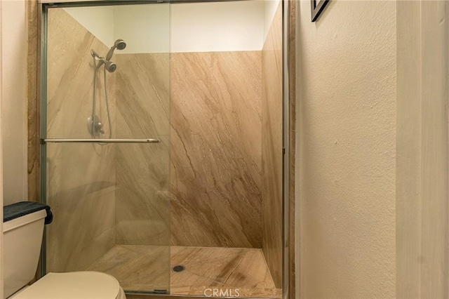 bathroom with toilet and an enclosed shower