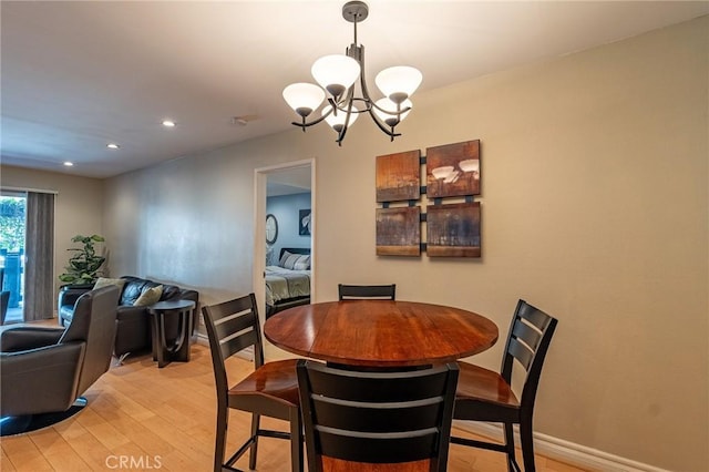 dining space featuring light wood-type flooring and a chandelier