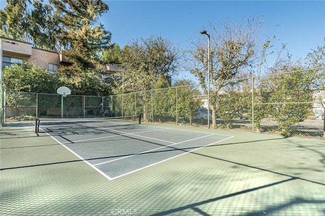 view of tennis court featuring basketball hoop