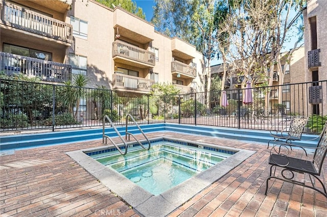 view of swimming pool with a community hot tub and a patio area