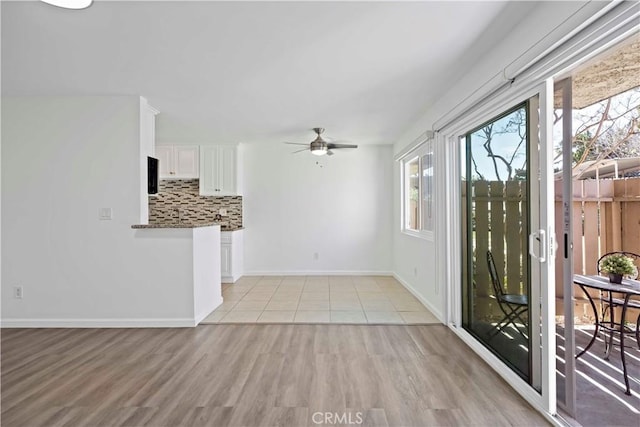 unfurnished living room with ceiling fan and light wood-type flooring