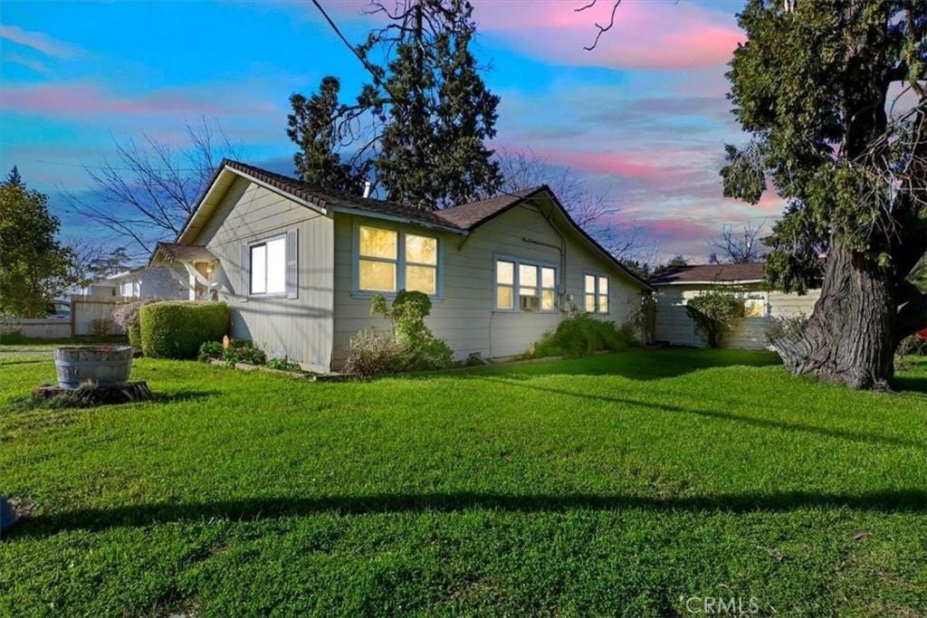 property exterior at dusk with a yard