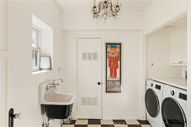 washroom featuring cabinets, separate washer and dryer, sink, and a notable chandelier