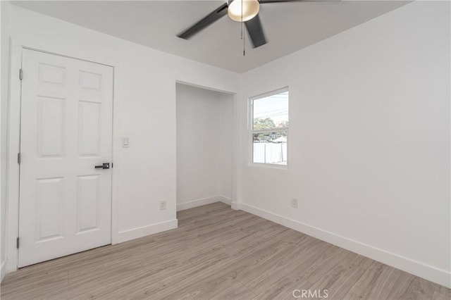 empty room with ceiling fan and light hardwood / wood-style floors