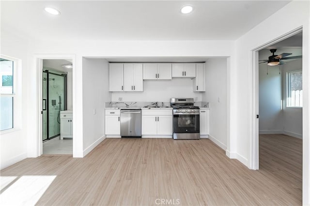 kitchen with ceiling fan, stainless steel appliances, light wood-type flooring, white cabinets, and sink