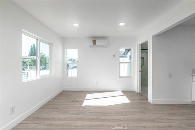 unfurnished room featuring light hardwood / wood-style flooring and a wall unit AC