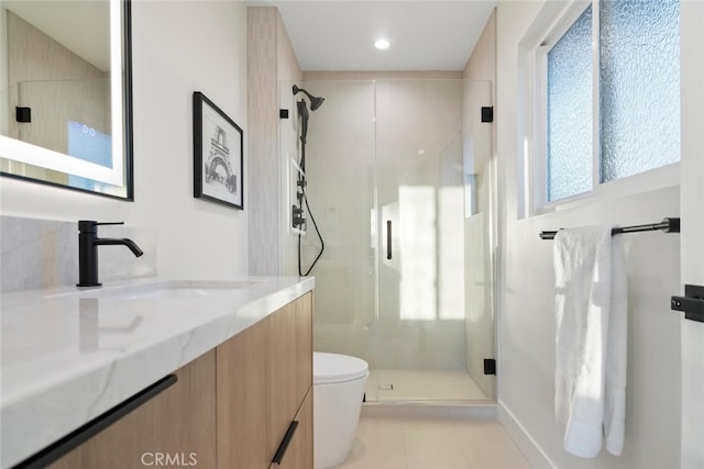 bathroom featuring vanity, toilet, plenty of natural light, and walk in shower