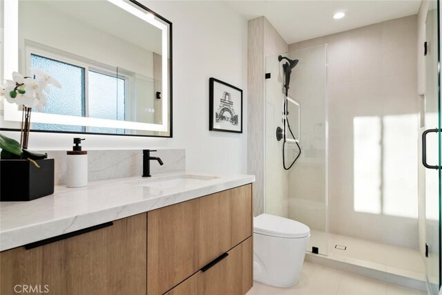 bathroom with walk in shower, vanity, tile patterned floors, and toilet