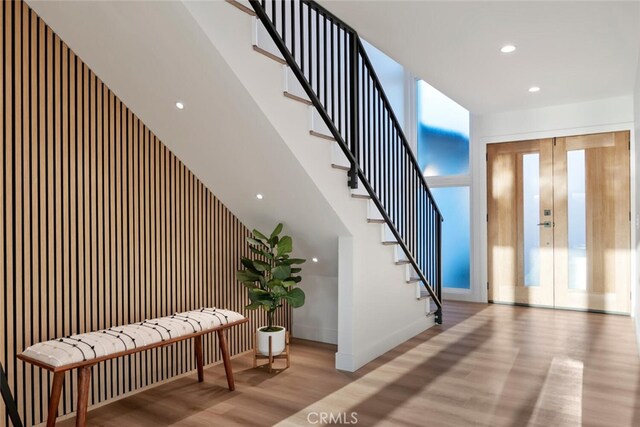 stairs with french doors and wood-type flooring