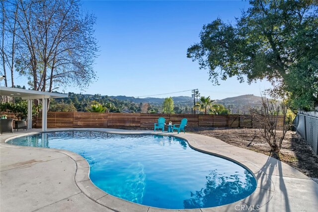 view of pool featuring a mountain view and a patio